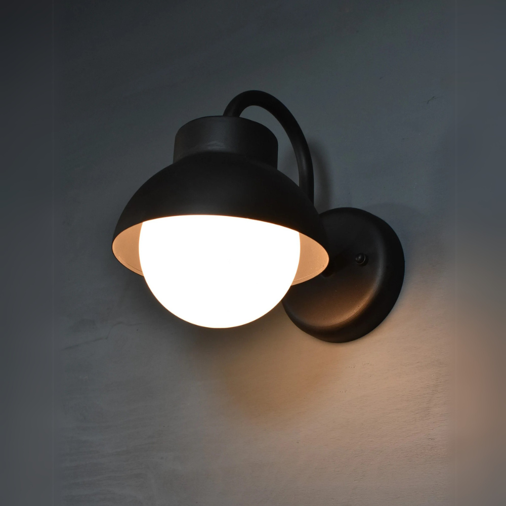 Verschönern Sie Ihren Raum mit dieser Wandleuchte im Industriestil mit elegantem, mattschwarzem Finish und einem klassischen, kuppelförmigen Lampenschirm. Die geschwungenen Arme und die freiliegende Glühbirne verleihen ihr einen klassischen und doch modernen Touch und machen sie perfekt für Schlafzimmer, Flure oder Leseecken. Diese Wandleuchte ist aus langlebigen Materialien gefertigt und bietet sowohl Stil als auch Zweckmäßigkeit, indem sie ein warmes, konzentriertes Licht für jede moderne, rustikale oder 